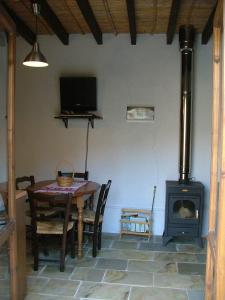 Episkopi PafouANOI 1-bedroom country House的一间带桌子和燃木炉的用餐室