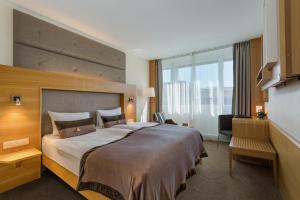 洛桑洛桑市大陆酒店的一间酒店客房,设有一张大床和一个大窗户