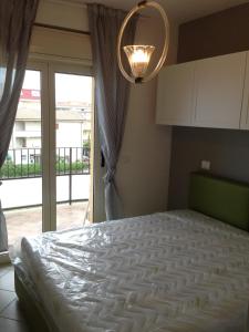 阿尔巴·阿德里亚蒂卡Appartamenti sul lungomare的一间卧室配有一张带窗户和吊灯的床。
