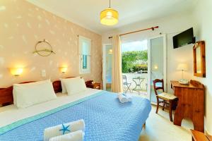利吉亚Alkyon Apartments & Villas Hotel的一间卧室设有蓝色的床和一个阳台