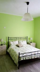 瓦尔玛德雷拉Locanda La Tana Del Luppolo的一间卧室配有一张带绿色墙壁的床