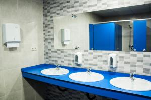 阿尔苏阿De Camino的浴室设有3个水槽和1个蓝色的台面