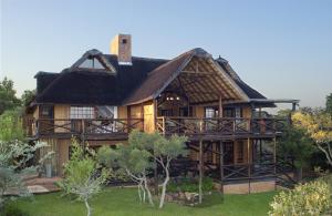 莫迪默勒Zwahili Private Game Lodge & Spa的茅草屋顶的大房子