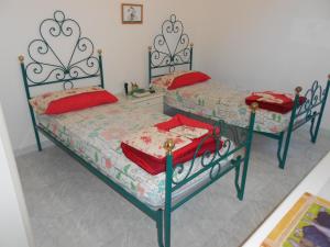 卡斯特拉巴特滨海B&B Isabella的两张带红色枕头的床,位于客房内