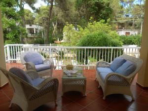 卡斯特拉巴特滨海B&B Isabella的庭院设有三把椅子、一张桌子和围栏