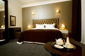 基希讷乌罗萨别墅酒店的酒店客房,配有床和桌子,上面有盘子