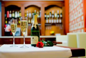 基希讷乌罗萨别墅酒店的一瓶香槟和一张桌子上的两杯酒