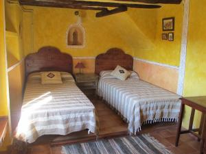CanetoEl Ensueño的黄色墙壁客房的两张床