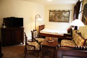 普拉哈季采克朗普拉查斯酒店的客厅配有床和桌椅