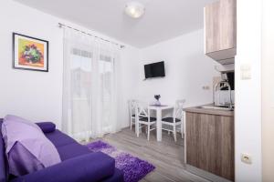 特罗吉尔戈佳一室公寓的客厅配有紫色沙发和桌子