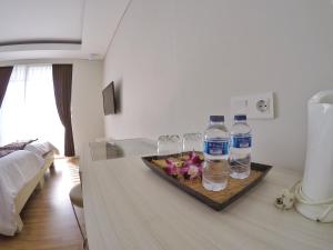 登巴萨彭多克奈曼15号旅馆的一间提供两瓶水和酒杯的房间