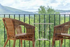 MindeRetiro do Bosque Country House的两把藤椅和一张桌子在栅栏前
