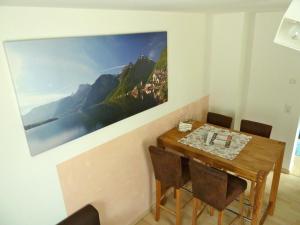 哈尔施塔特Haus Salzberg的餐桌、椅子和墙上的绘画