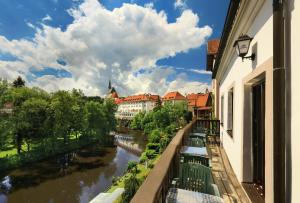 捷克克鲁姆洛夫坢休恩泰迪酒店的享有河流和建筑景致的阳台