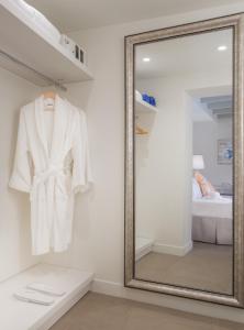 伊西翁Mareggio Exclusive Residences & Suites的更衣室的镜子,带白色浴袍