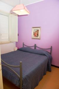卡里尼Lomarchi Holiday Home的一间卧室配有一张紫色墙壁的床