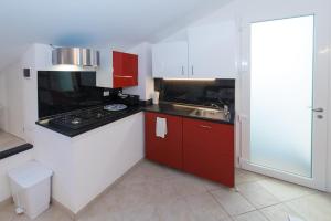 菲纳莱利古雷Mansarda Cavassola的厨房配有红色和白色的橱柜和水槽