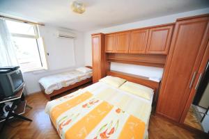 奥帕提亚Rooms Novaković的一间带床和电视的小卧室