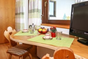 新波南特Alps Residence的一张桌子,上面放着一碗水果和一台电视