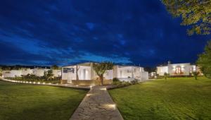 伊西翁Mareggio Exclusive Residences & Suites的夜晚在院子里的一排白色房子