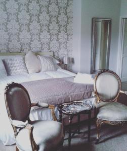奥特本The Coach House的一间卧室配有一张带两把椅子和一张桌子的床。