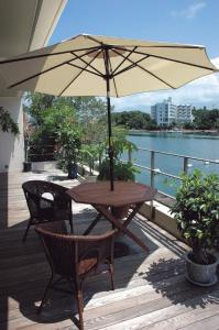 白滨鲁安冬白滨酒店的甲板上配有一张木桌和椅子及遮阳伞