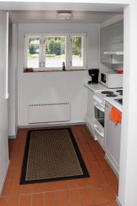 萨洛Vuohensaari Camping的厨房配有白色橱柜和炉灶烤箱。