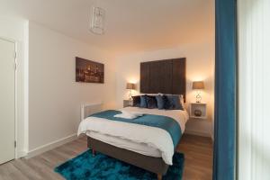 伦敦豪华伦敦公寓的一间卧室配有一张蓝色地毯的大床
