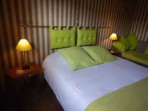 蒙斯B&B La Chrysalide的一间卧室配有一张带绿色床头板的床和两盏灯。