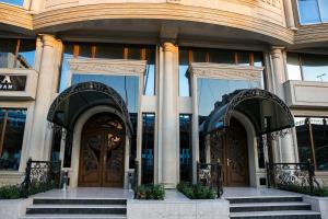 巴库Azalea Hotel Baku的前方设有两扇大门和楼梯的建筑