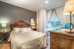 桑坦德拉斯布里萨公寓酒店的一间卧室配有一张床、一张书桌和一个窗户。