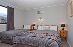 阿什伯顿克罗纳特恩公园假日酒店的一间卧室设有两张床和窗户。