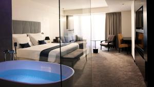 波尔托罗Hotel Slovenija - Terme & Wellness LifeClass的酒店客房带一张床和浴缸