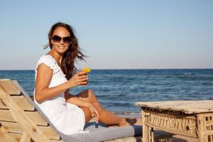 达哈布Eldorado Lodge and Restaurant的坐在沙滩椅上喝一杯的女人