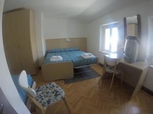 Staranzano阿尔贝格拉卡拉维拉酒店的一间小卧室,配有一张床和电视