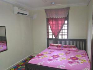 哥打巴鲁Z&R民宿的卧室配有粉红色的床和窗户。