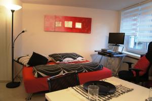 豪尔根荷根一室公寓及公寓酒店的客厅配有红色的沙发和桌子