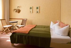 柏林科萨克裴森酒店的酒店客房带一张床、一张桌子和椅子