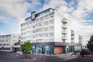 雷克雅未克Hotel Ísland – Spa & Wellness Hotel的街道上带窗户的大型白色建筑