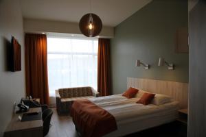 哈德洛姆斯塔泽哈勒姆斯特德尔酒店的卧室配有床、椅子和窗户。