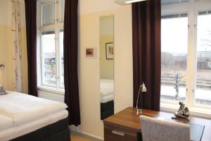 雪平莉拉站酒店的一间卧室配有一张床和一张带镜子的书桌