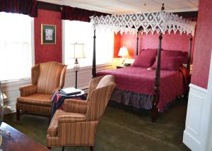 佩托斯基斯塔福德海湾景酒店的一间卧室配有一张天蓬床和一把椅子