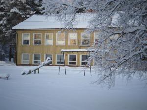 Väster GafseleGafsele Lappland Hostel的雪中带游乐场的房子