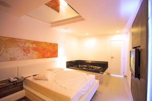 萨尔瓦多DOM Suites motel (Adult Only)的一间卧室配有一张床和一台电视