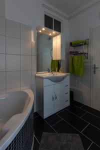 格拉茨Flataid Apartment Elisabethinergasse的带浴缸、水槽和镜子的浴室