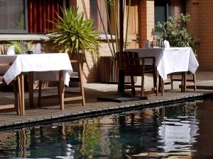 塔那那利佛萨卡曼加酒店的水泳池旁的桌椅