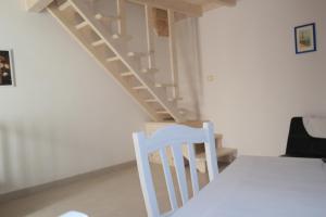 普雷西切Casa Vacanze Presicce的白色的楼梯,房间配有桌子和椅子