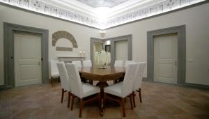 佛罗伦萨文艺复兴酒店的一间带木桌和白色椅子的用餐室