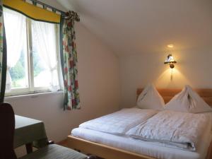 湖滨福煦Garni Haus Jagerwirt的卧室配有白色的床和窗户