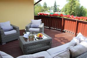 波普拉德Boutique Hotel Villa ZAUBER的阳台配有椅子和一张桌子及一碗水果